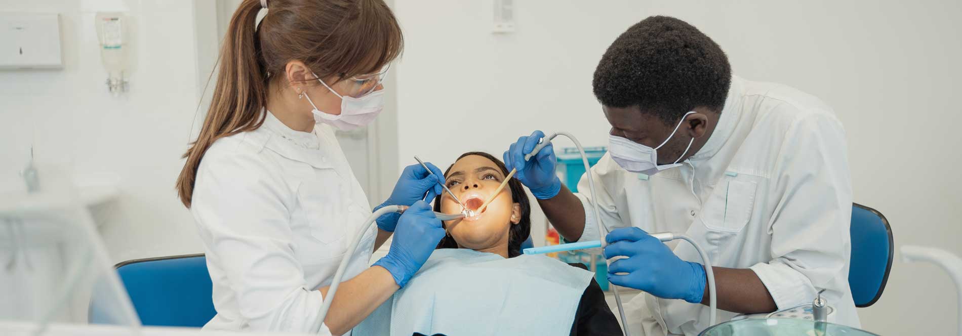 Female and male dental professionals working on female patient
