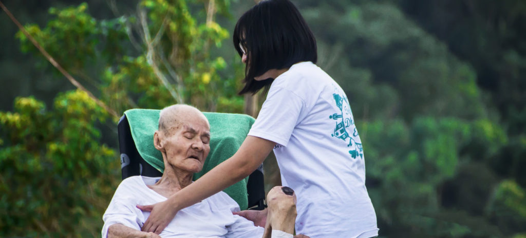 Home Health Aide Helping Elderly Patient