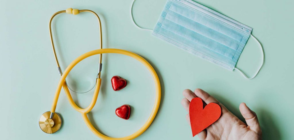 Mask, stethoscope, heart in hand